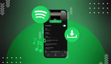 Mobile phone displaying the Spotify app interface with music playlist and download options.
